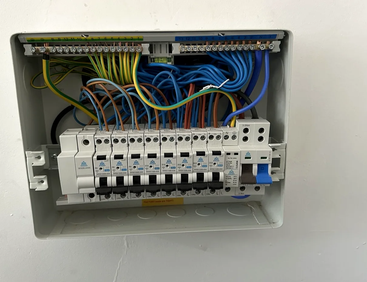 Interior of a single-phase consumer unit with visible conductors and protective devices